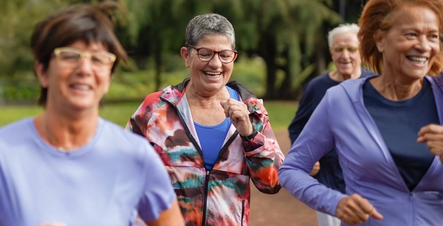 A group of older women exercising together with happy smiles on their faces