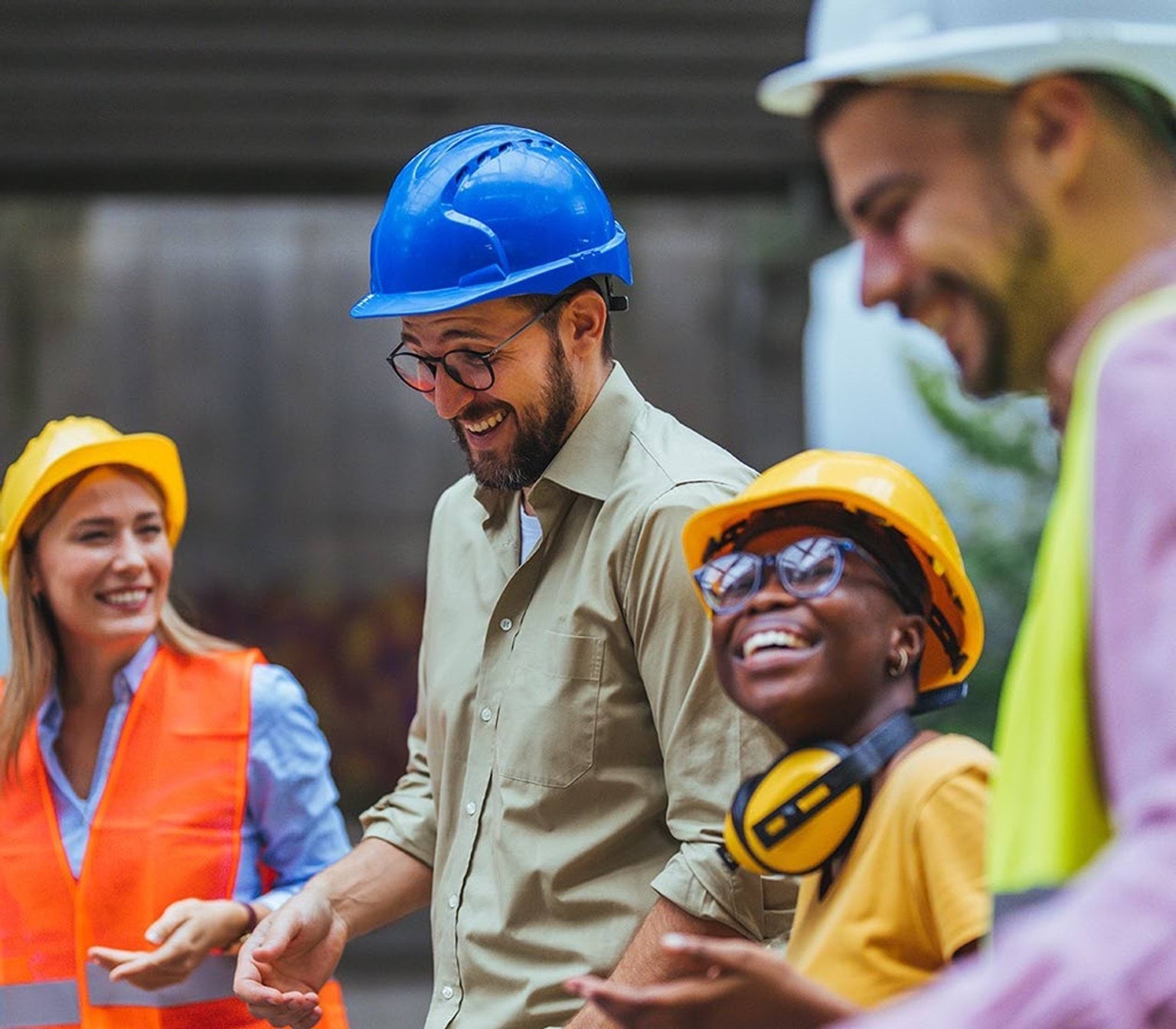 Several workers smiling whilst wearing hard-hats